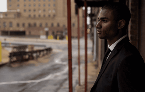 Side profile of African American man in suit standing outside
