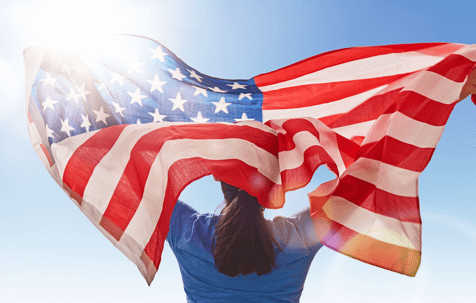 Woman holding an American flag behind her back